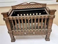 Front and angled view of vintage metal fireplace insert showing its architectural design, rusty patina, and perforated inner back plate.