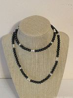 Full view of the vintage necklace displayed on a beige textured bust showing alternating hematite beads and freshwater pearls.