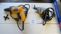 Dewalt yellow and black 1/2" hammer drill alongside older gray drill, both with power cords and separate drill keys.