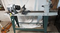 Full side view of the Mastercraft wood lathe on a green metal stand showing length and overall structure.