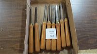 Set of 8 wood lathe tools laid out in a box showing wooden handles and metal blades.
