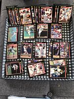 Photo of arranged group of 1991 Score baseball cards laid flat on cloth, showing various players in typical sports action shots with black card borders and gold text.