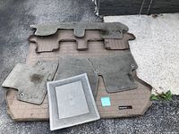 Top view showing all mats laid out on ground, including large brown rubber cargo mat and smaller carpeted mats.