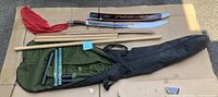 Full set of items laid out on flat surface showing sword, staffs, nunchaku, and bags