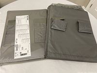 Two gray IKEA SKUBB hanging closet organizers, one used and one in plastic packaging with IKEA label visible.