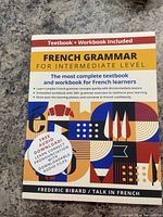 Front cover of book titled 'French Grammar for Intermediate Level' by Frederic Bibard with colorful abstract design. Text states it includes textbook and workbook.