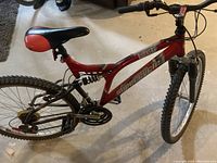 Full side view of the red and black SimpleCycle Burpee mountain bike with visible frame, wheels, seat, and handlebars.