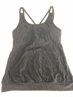 Black Tonic tank top with tonal swirls pattern, double shoulder straps crossed at back, laid flat on light background.