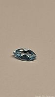 Photographs of a natural sky blue marquis cut topaz gemstone showing its shape, color, and clarity.