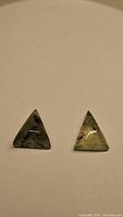 Pair of triangular shaped natural rutilated prehnite gemstones with mossy green color and internal rutile inclusions, polished fancy cut.