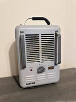 Front view of Patton electric heater showing vents, control knob, and handle.