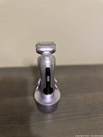 Front view of silver Remington NoCord electric razor on charging stand