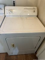 Front view of white Maytag gas dryer showing control panel with single dial and door with handle.
