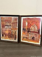 Both Liz Myhill prints side by side in dark wood frames showing Two By Two on left and The Dawn on right