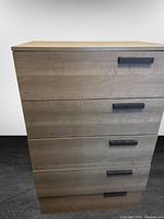 Front view of the 4-drawer dresser showing wood finish and black handles.