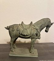 Side view of the Tang horse sculpture showing the detailed saddle and decorative tassels