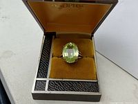 Front view of pale green oval peridot ring in an open velvet ring box.