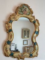 Overall front view of the gilt framed mirror hung on wall