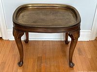 Front view of wooden side table with brass tray inserted
