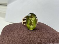 Front view showing large oval faceted green stone and split shoulder band