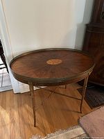 Full front view of oval side table showing gallery edge and faux bamboo legs
