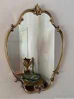 Front view of the mirror hung on wall showing overall shape, frame and reflective surface