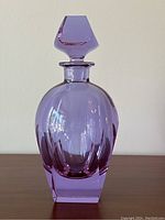 Front view of purple crystal decanter with stopper