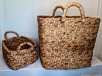 Both handcrafted water hyacinth baskets side by side, showing their relative sizes and braided texture.