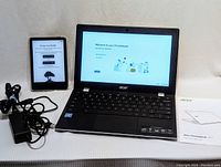 Full view of Acer Chromebook, Kindle eReader, cables and setup guide