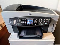 Front view of HP Officejet 7310xi All-in-One printer showing control panel, buttons, and paper output tray.