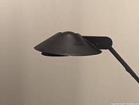 Close-up of the black metal conical lampshade showing design and finish.