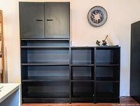 Three-module shelving system with tall cabinet module on left and two open bookshelf modules on right