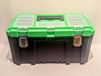 Closed heavy-duty black plastic toolbox with green lid and metal latches