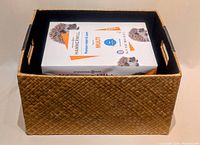 Yellow palm leaf woven box with leather handle patches holding 3 reams of Hammermill printer paper
