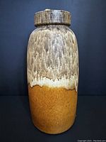 Front view of the large ceramic pot showing the two-tone yellow and brown glaze.