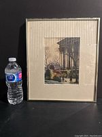 Photo of framed art print next to a water bottle for size reference. Print measures approximately 8 x 6 inches and is framed under glass in a metal frame.