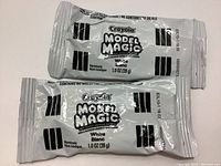 Photo shows two packs of Crayola Model Magic, each in sealed white packaging, 28g each.