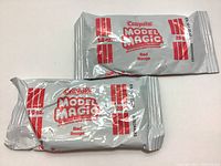 Photo showing two unopened packs of Crayola Model Magic modeling material in red, 28 grams each.