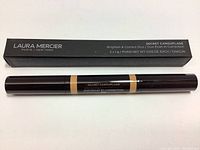 Photo of boxed Laura Mercier Secret Camouflage Brighten & Correct Duo Concealer pen with black rectangular box packaging showing product name and details.