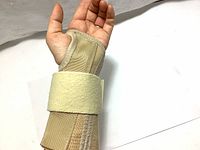 Wrist support brace displayed on a hand demonstrating fit and strap closure.