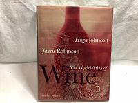 Front cover of The World Atlas of Wine 5th Edition hardcover book, showing authors Hugh Johnson and Jancis Robinson, and artistic wine vine design.