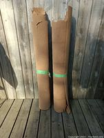 Two standing cork board rolls secured with green tape, showing slight edge damage.