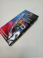 Boxed NHL candy cane shaped like hockey stick ads, viewed from front.