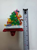 Front view of Disney ceramic stocking holder with ruler showing height.