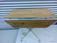 Folded retro wood kitchen dining table with sturdy metal frame showing rectangular top with folded drop-leaves