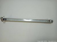 Full length view of industrial LED tube light showing transparent housing with visible LED circuitry inside, connectors at both ends with wiring visible on one side.