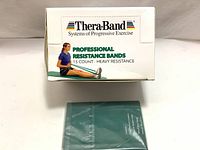 Box of Thera-Band Professional Resistance Bands showing branding, quantity, and usage illustration.