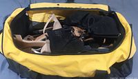 Yellow gym bag open showing two pairs of ladies shoes inside - one pair black lace-up heels with perforation and one pair nude/beige high heel sandals with straps.