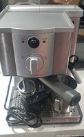 Front view of the Breville Cafe Aroma coffee machine showing control dial, indicator lights, and included accessories such as portafilter and tamper.