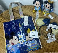 Photo showing reusable bag with Mickey and Minnie Mouse in 50th anniversary attire, castle and fireworks design.